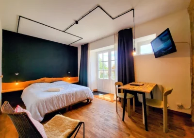 Chambre de Marius à La Maison Folia, maison d’hôtes en Normandie, avec lit double, bureau et télévision