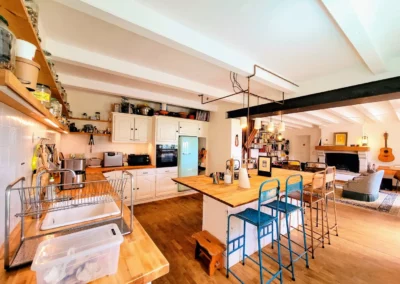 Cuisine et salon de La Maison Folia, maison d’hôtes en Normandie, avec îlot central et espace convivial